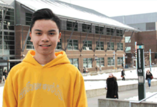 Smiling young man in  a yellow hoodie. 